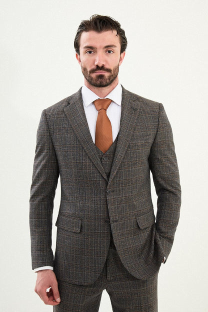 Men’s brown glen plaid slim-fit three-piece wool-blend suit with single-breasted two-button jacket, notch lapels, patch pockets, five-button waistcoat, tapered trousers, barchetta chest pocket, and black origami lapel pin.