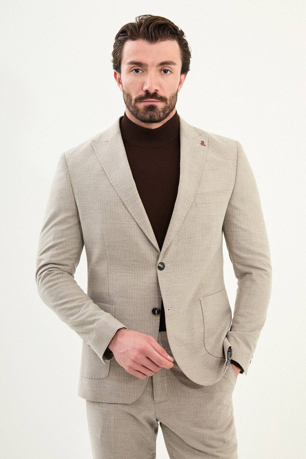 Men’s beige slim-fit mono-collar (mandarin collar) winter suit with minimalist single-breasted jacket, matte micro-texture active-recovery fabric, styled with a dark brown turtleneck.