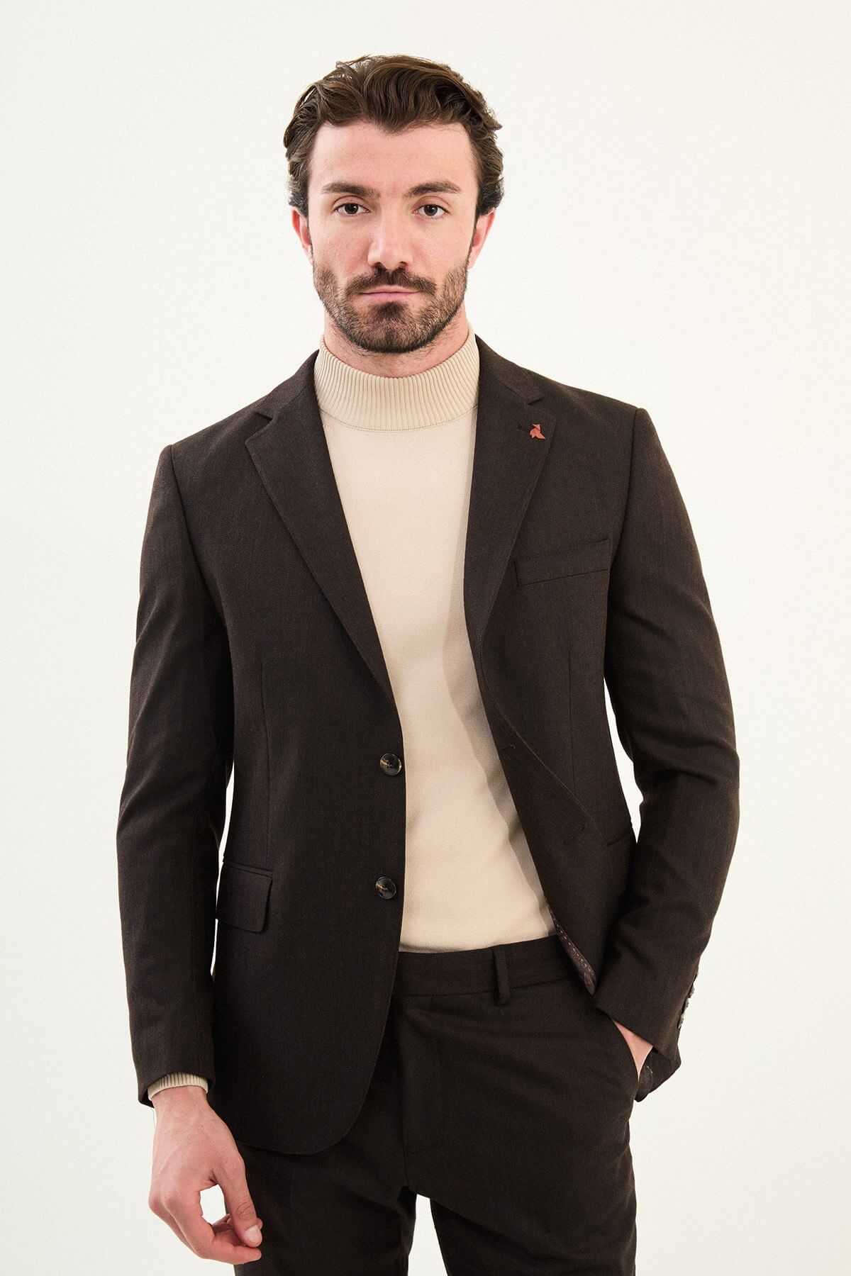 Men’s deep brown slim-fit single-breasted wool-blend suit with notch lapels and matte finish, high-wool fabric with stretch for winter wear, styled with a cream turtleneck for tonal dressing.
