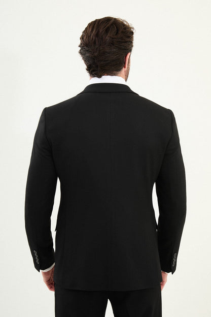 Men’s matte black slim-fit three-piece wool-blend winter suit with single-breasted jacket, notch lapels with AMF stitching, high-cut five-button waistcoat, tapered trousers, and black origami lapel pin.