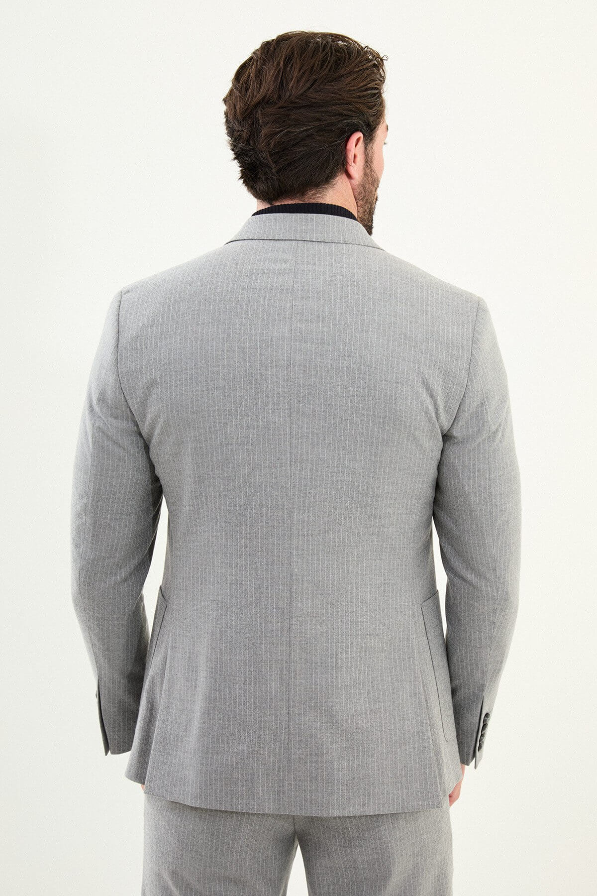 Men’s gray slim-fit mono-collar (mandarin collar) performance suit with 2-button single-breasted jacket, minimalist patch pockets, matte micro-texture fabric, styled with a black turtleneck.