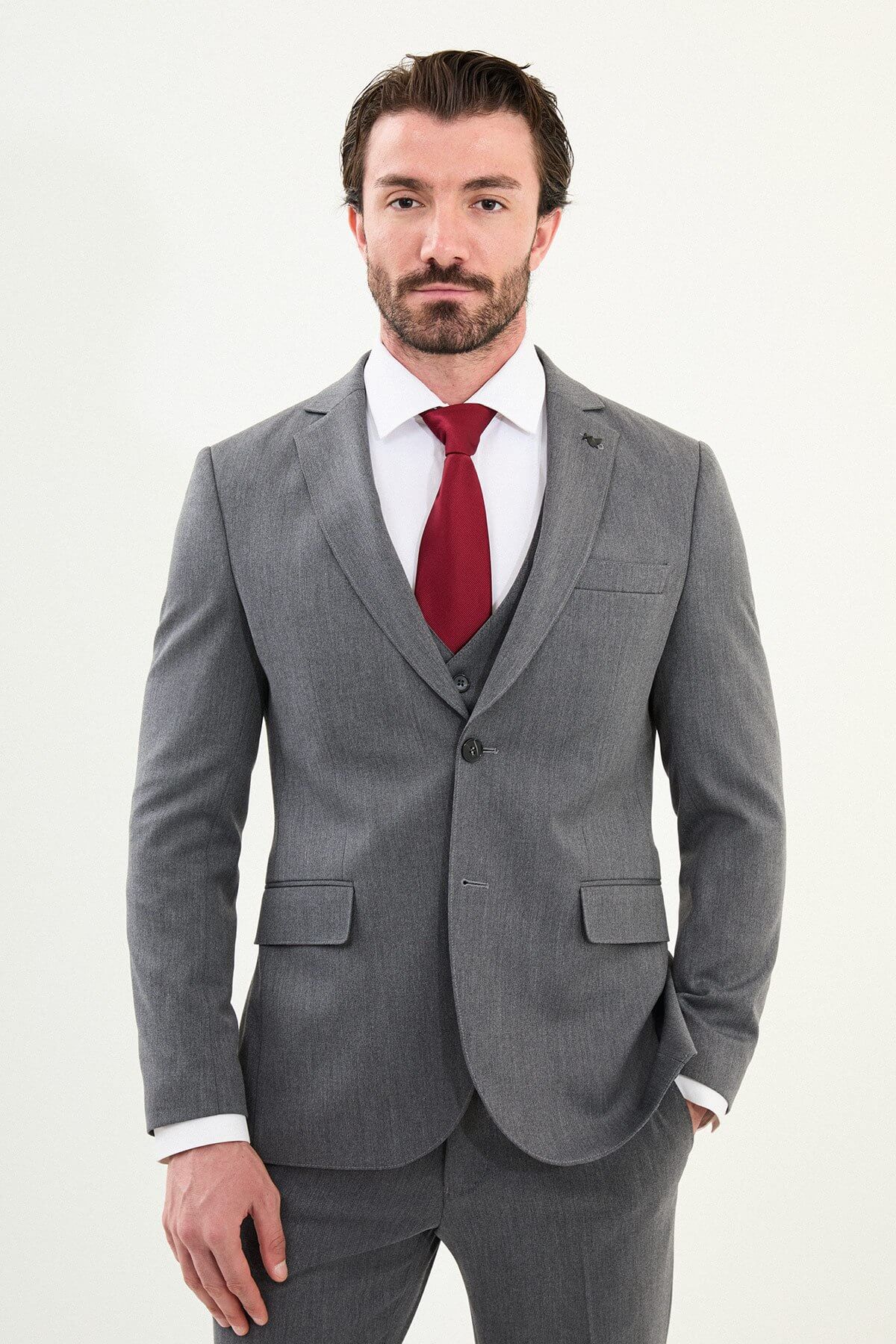 Men’s micro-heathered gray slim-fit three-piece winter suit with single-breasted 2-button jacket, 5-button waistcoat, notch lapels with AMF stitching, and black origami lapel pin.