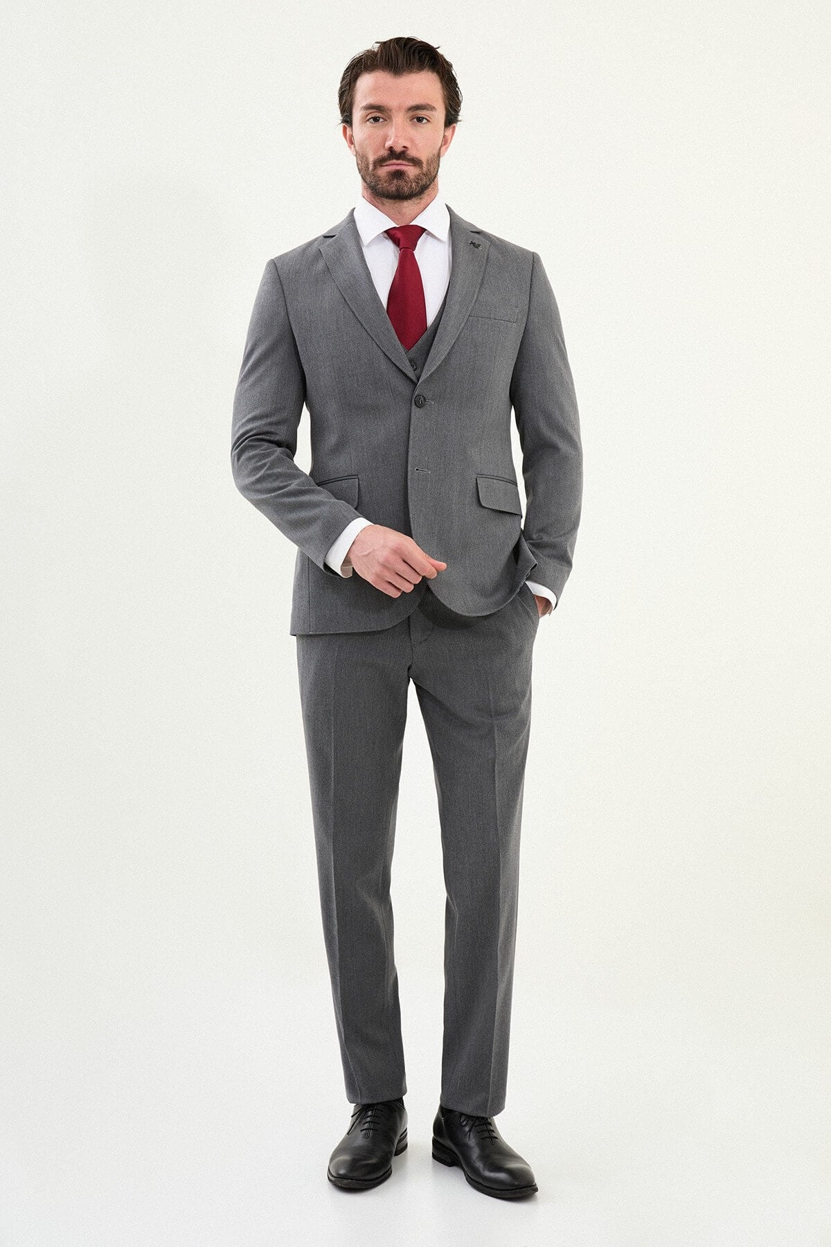 Men’s micro-heathered gray slim-fit three-piece winter suit with single-breasted 2-button jacket, 5-button waistcoat, notch lapels with AMF stitching, and black origami lapel pin.