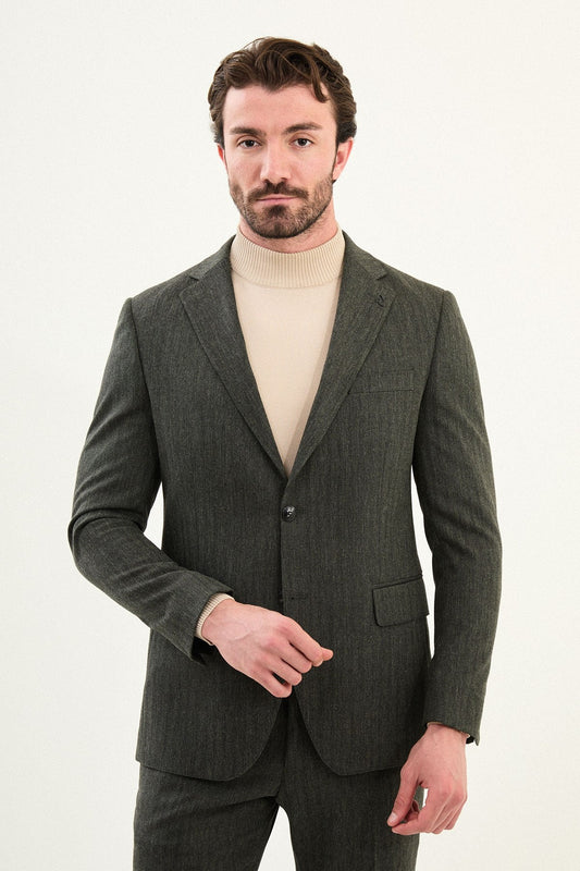 Men’s olive-toned khaki herringbone slim-fit single-breasted suit with structured shoulders and tailored waist, high-wool blend fabric with stretch for winter wear, styled with a cream fine-gauge turtleneck.