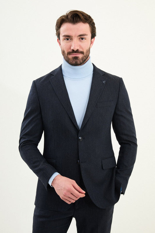 Men’s matte navy blue slim-fit single-breasted wool-blend suit with notch lapels and two-button closure, high-wool fabric with stretch for wrinkle-resistant winter wear, styled with a light blue turtleneck.